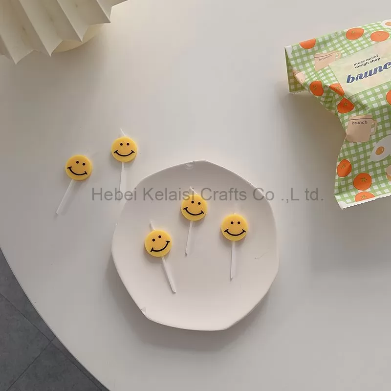 Yellow smiley face cartoons decorate birthday candles